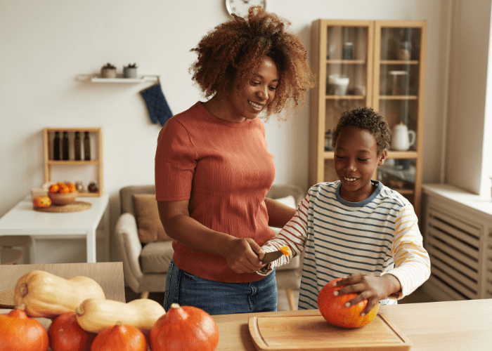 mom and son carving pumpkin as fall activities for kids